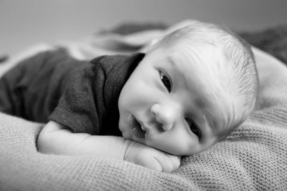 A sequence of peaceful close-up shots showing a sleeping baby on soft white bedding.