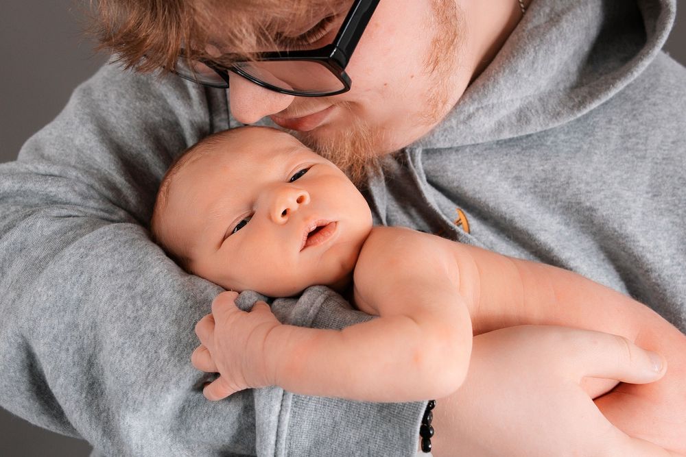An intimate series of black and white photographs capturing tender moments between parents and their newborn.