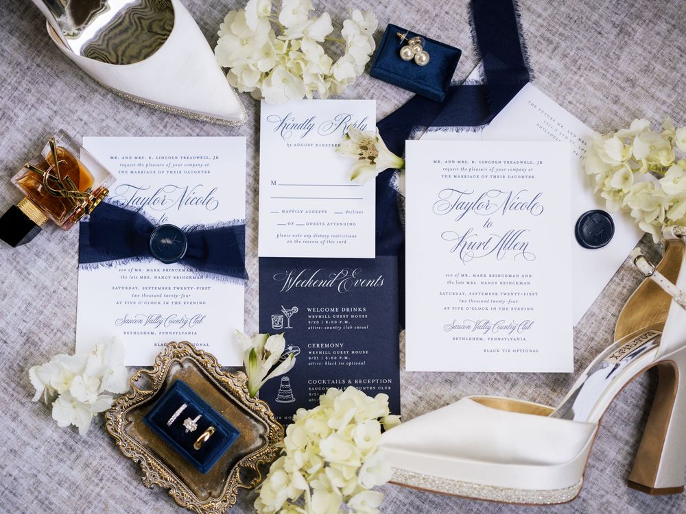 Wedding stationery suite in navy and white with floral accents and elegant calligraphy.