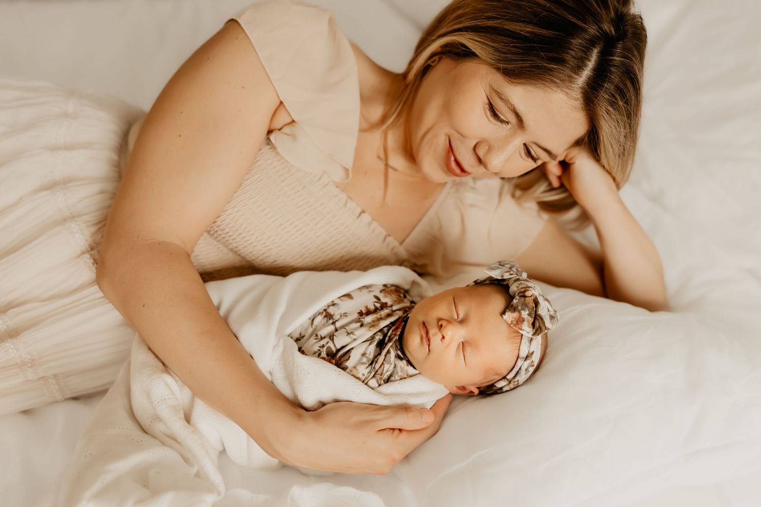 A Honolulu Newborn Photographer captures a mother looking down at her newborn baby girl.