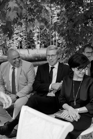 A group shares joyful laughter while sitting together outdoors.