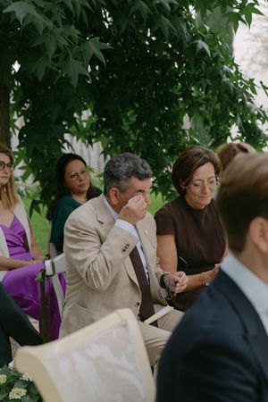 Candid moment of wedding guests laughing during outdoor reception.