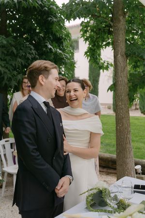 A couple shares a lighthearted moment during their outdoor garden wedding ceremony.