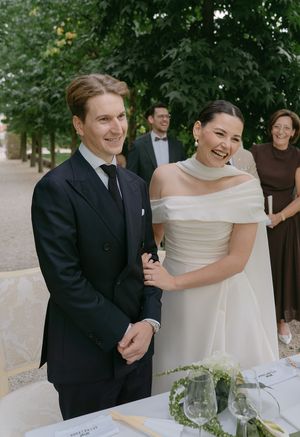 Candid moment of a couple laughing together at their garden wedding reception.