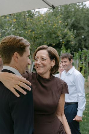 Joyful outdoor garden celebration with guests sharing warm embraces.
