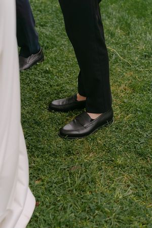 White tablecloth and dress details against green grass at an outdoor wedding reception.