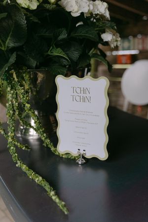 Decorative menu card labeled 'TCHIN' displayed among floral arrangements.