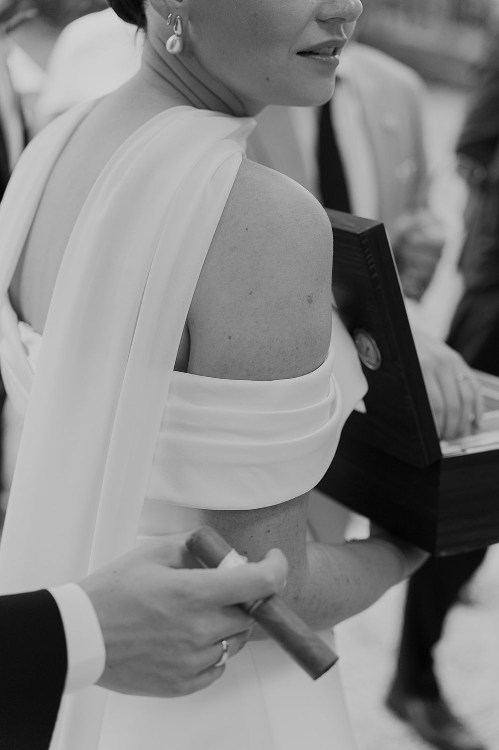 Detail shot of structured white wedding dress bodice and shoulder in black and white.