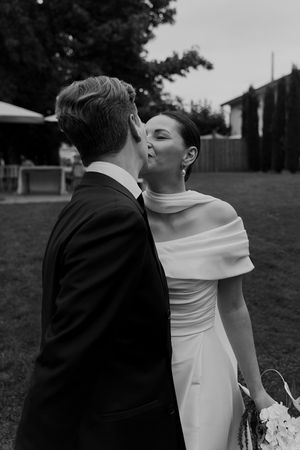 Intimate black and white wedding moment captured in an outdoor garden setting.