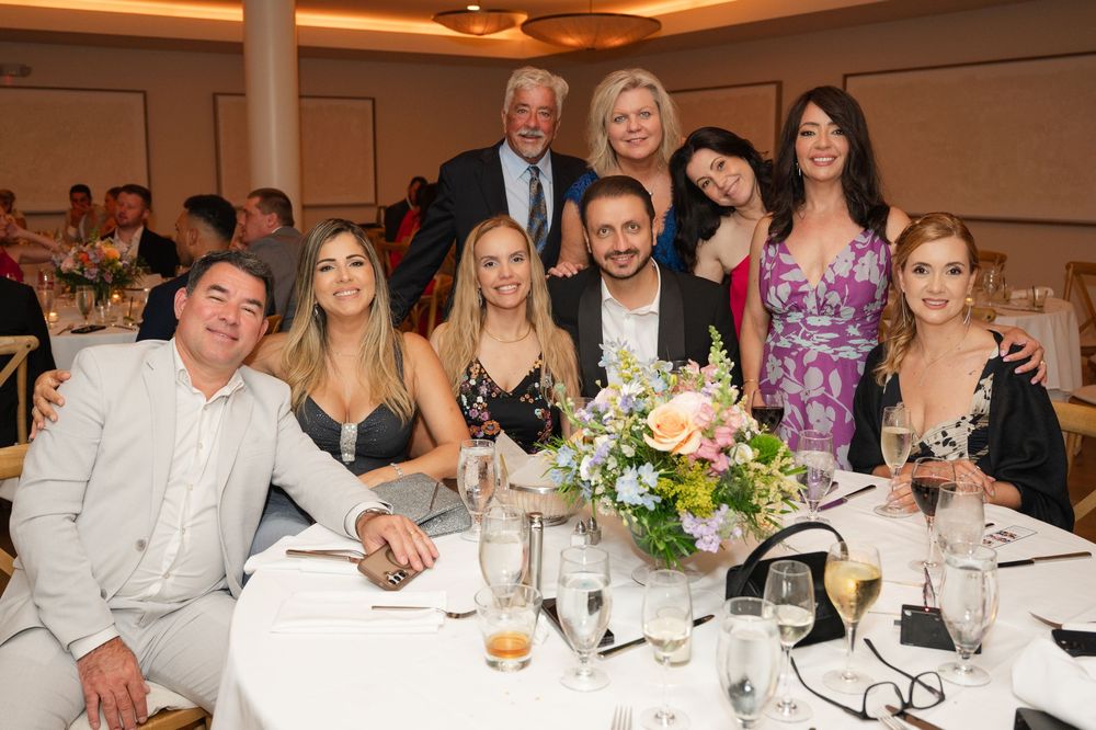 Guests enjoy dinner and conversation at elegant tables during a formal wedding reception.