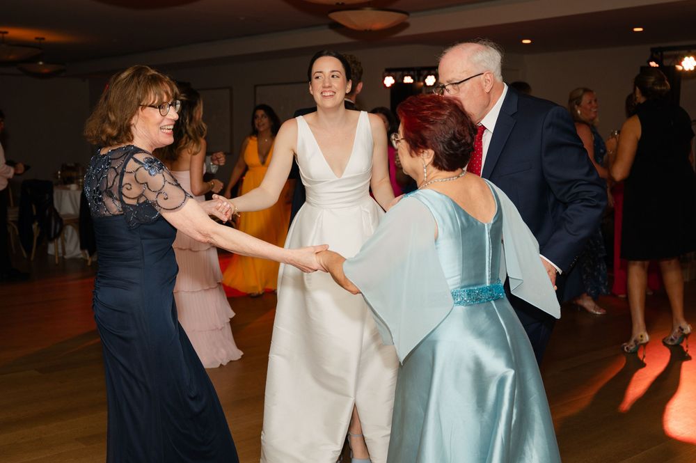 Guests dancing and socializing at a formal event with warm ambient lighting and elegant decor.