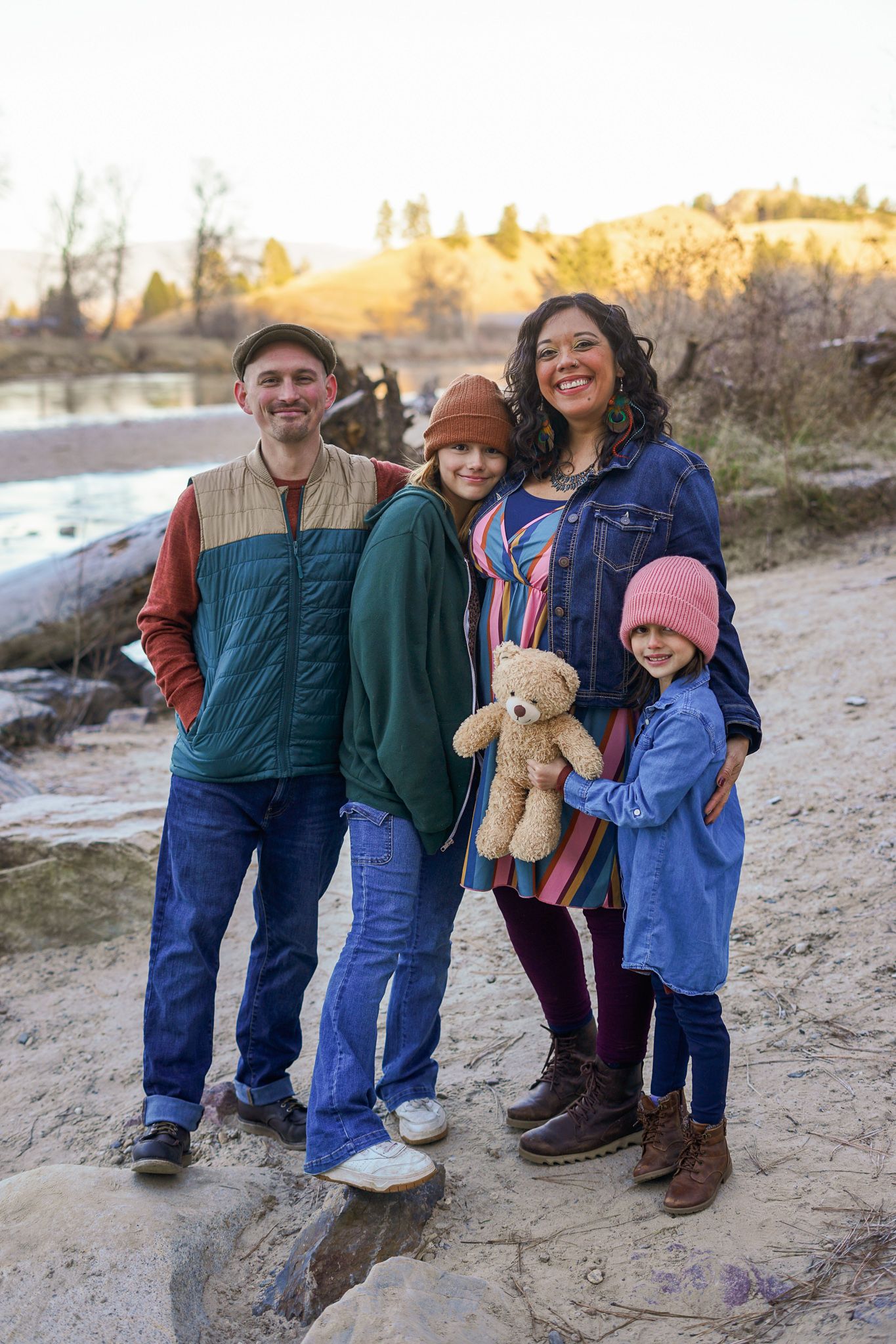 A group stands together outdoors on a sandy path during golden hour as the sun sets.