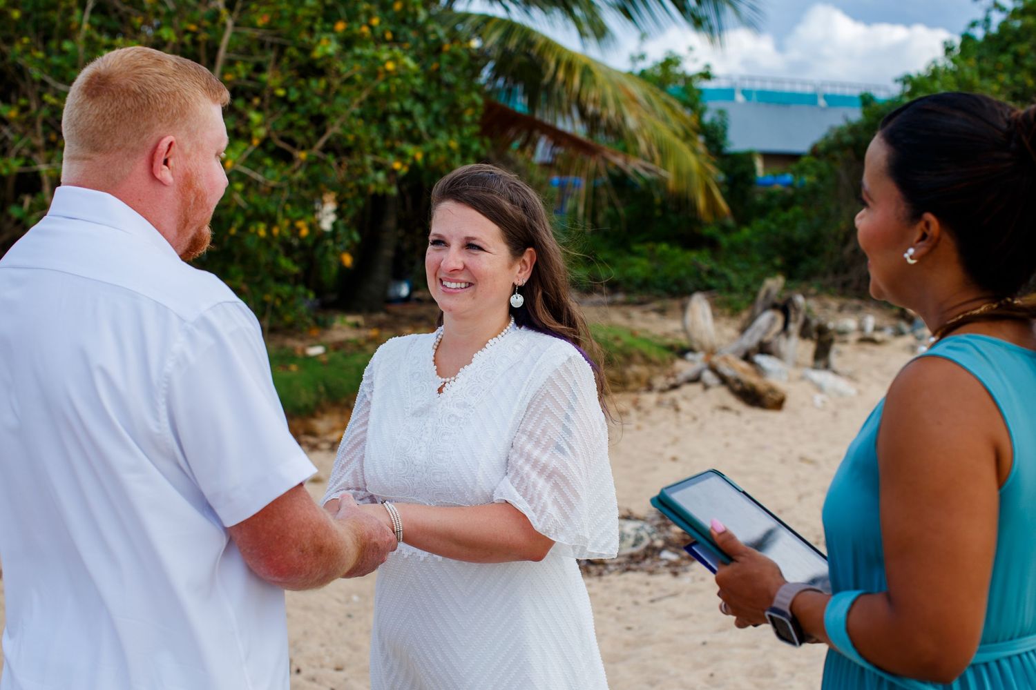Elopement on the beach at Balneario del Escambrón in Old San Juan, Puerto Rico. Wedding ceremony. Bride, groom, and officiant.
