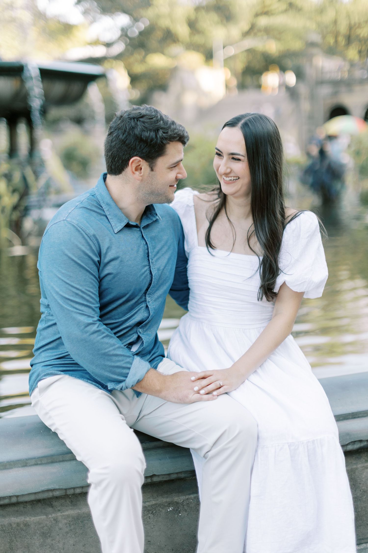 A couple in blue and white outfits share intimate moments by a waterfront in a multi-panel photo sequence.