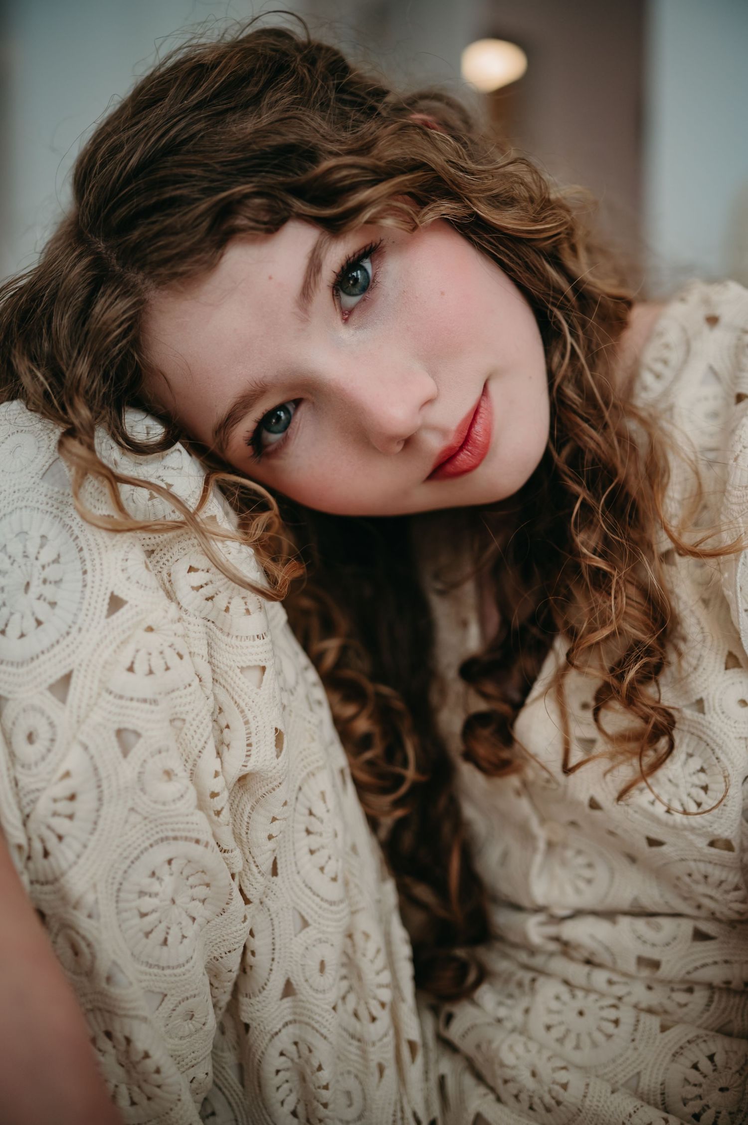 A collection photographs captured in warm tones showing a vintage-style lace dress and wavy brown hair.