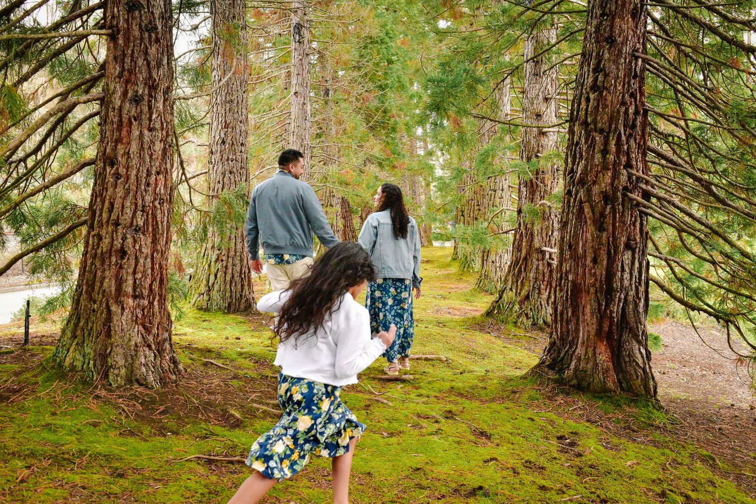 Family walking together through forest during fall family session in Seattle