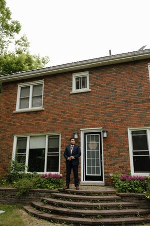 A sequence of four photos showing a brick house exterior with tiered garden steps and flowering shrubs.