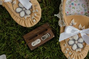 Handmade leather coasters with white butterfly decorations arranged in a circle on green grass.