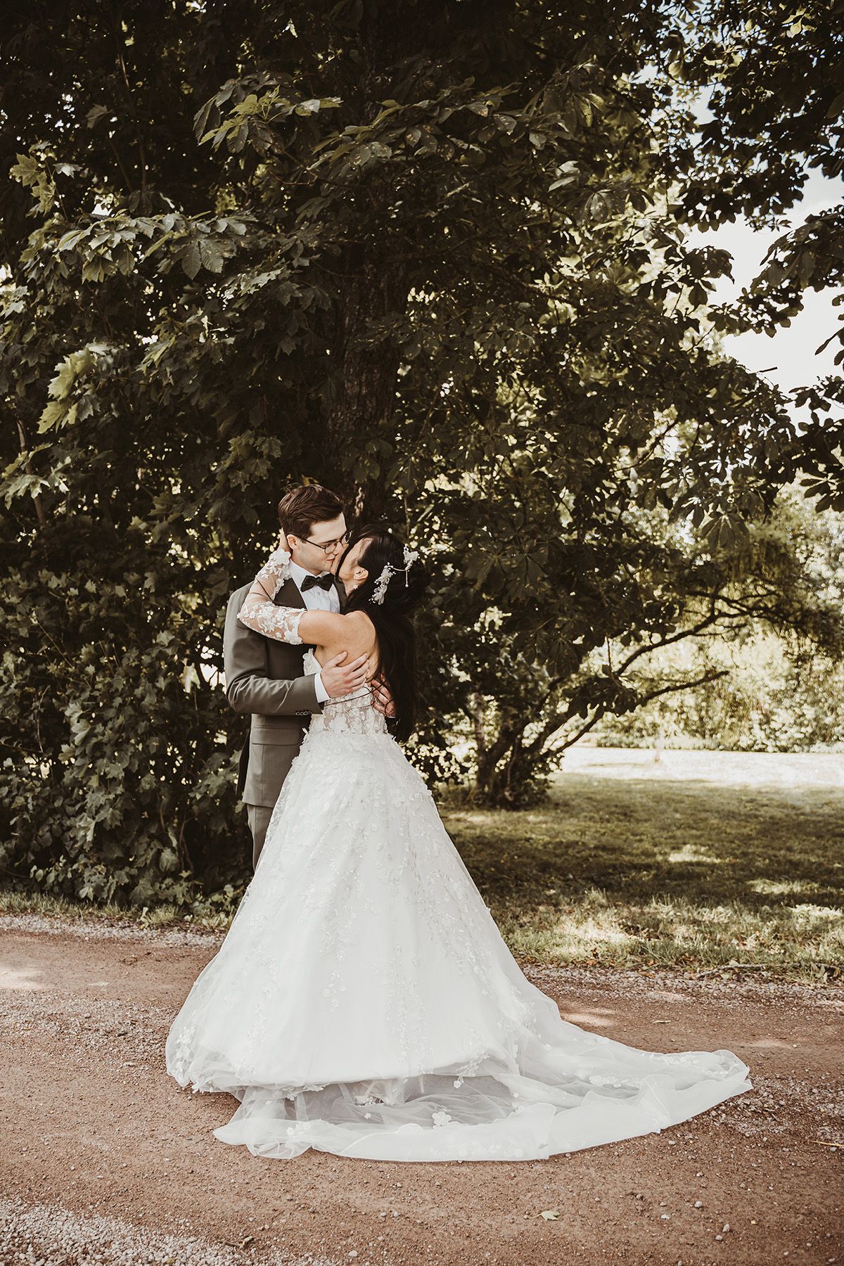 Vacker porträtt av brudpar som kysser varandra under First Look-fotografering i Vadstena, fotografering av Lets Bloom Media.
