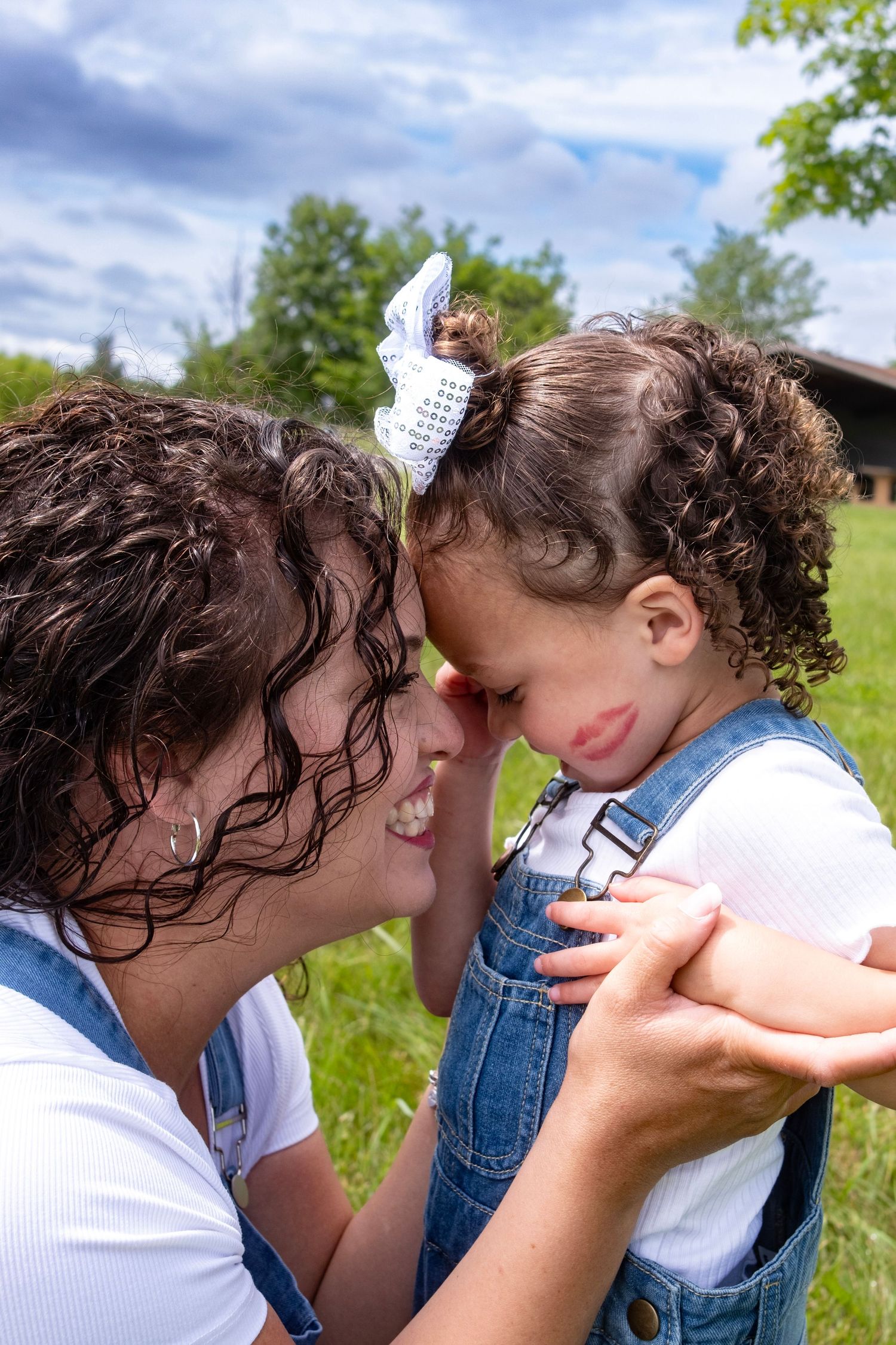 Two people sharing tender moments in a sunny green field.