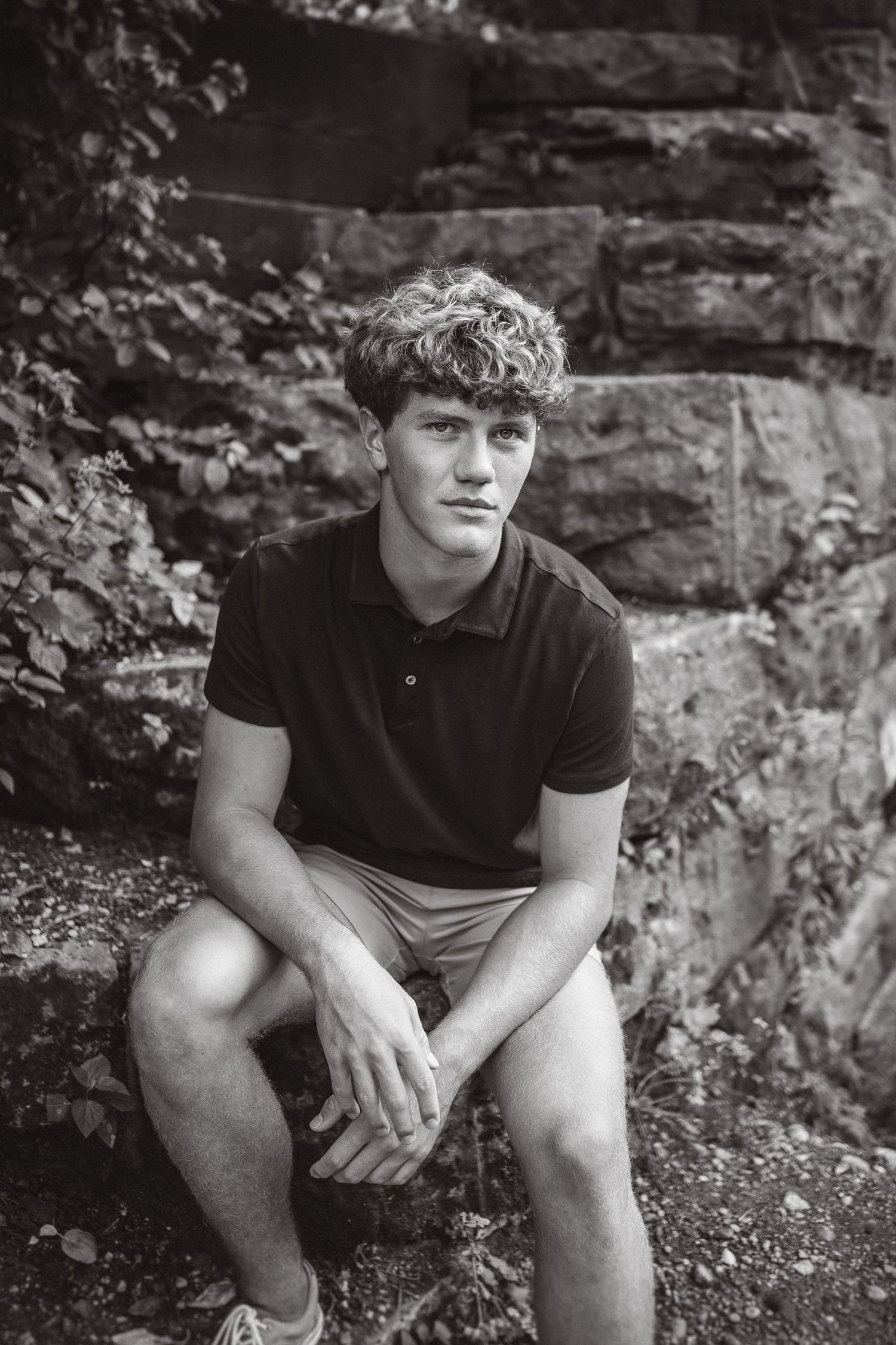 Black and white portrait against stone wall backdrop with casual summer attire.