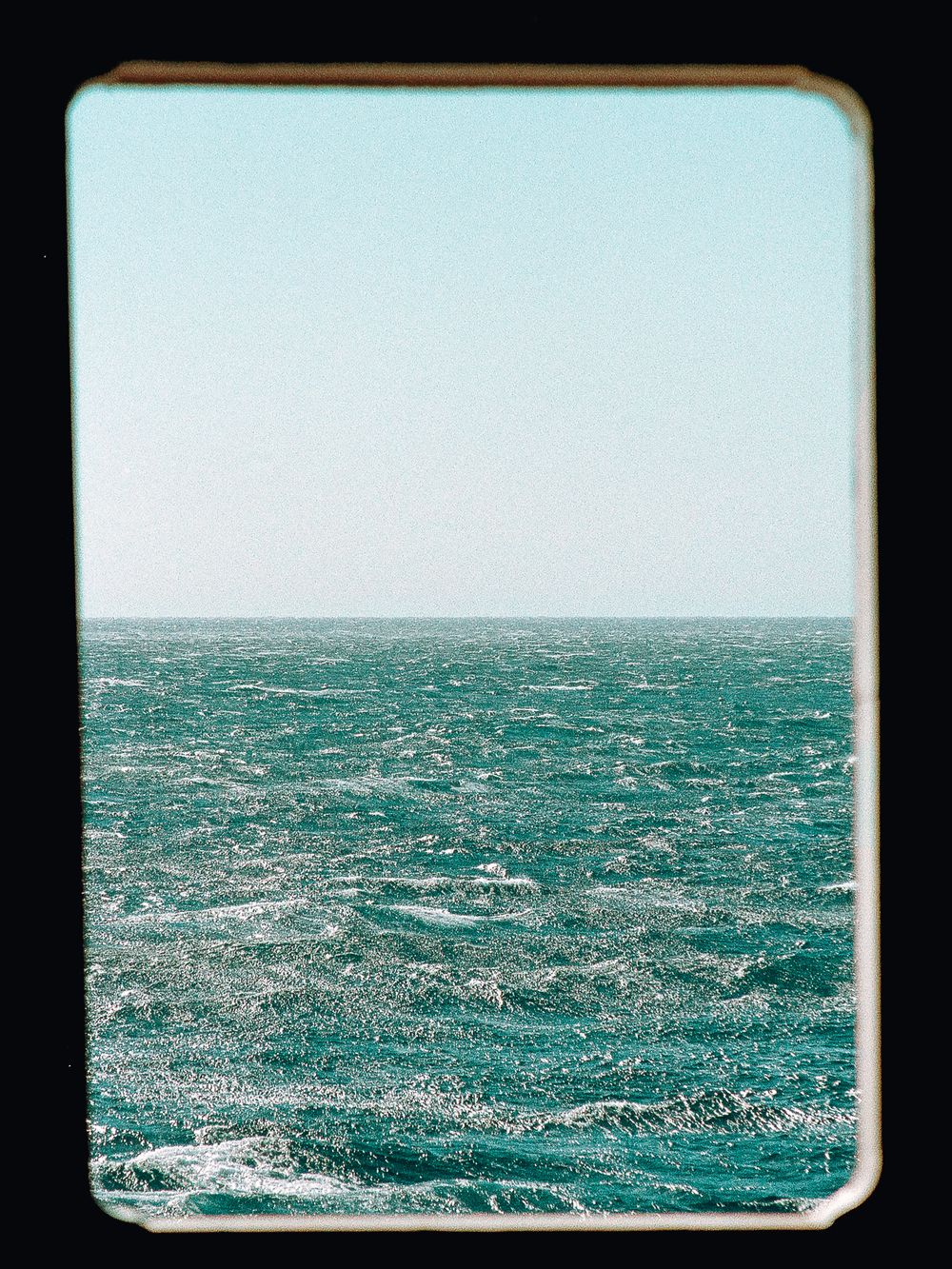 Open sea view framed by a ferry window.
