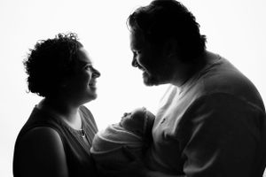 Black and white silhouette portrait of a couple sharing an intimate conversation moment against a white background.