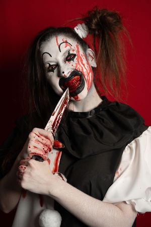 Crazy clown bloody horror funny girl with red eyes special effects makeup.