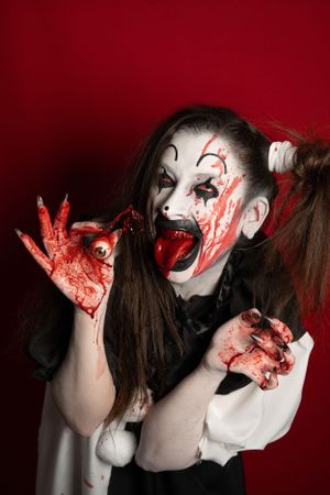 Crazy clown bloody horror funny girl with red eyes special effects makeup.