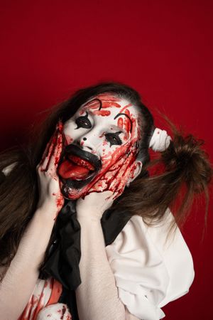 Crazy clown bloody horror funny girl with red eyes special effects makeup.