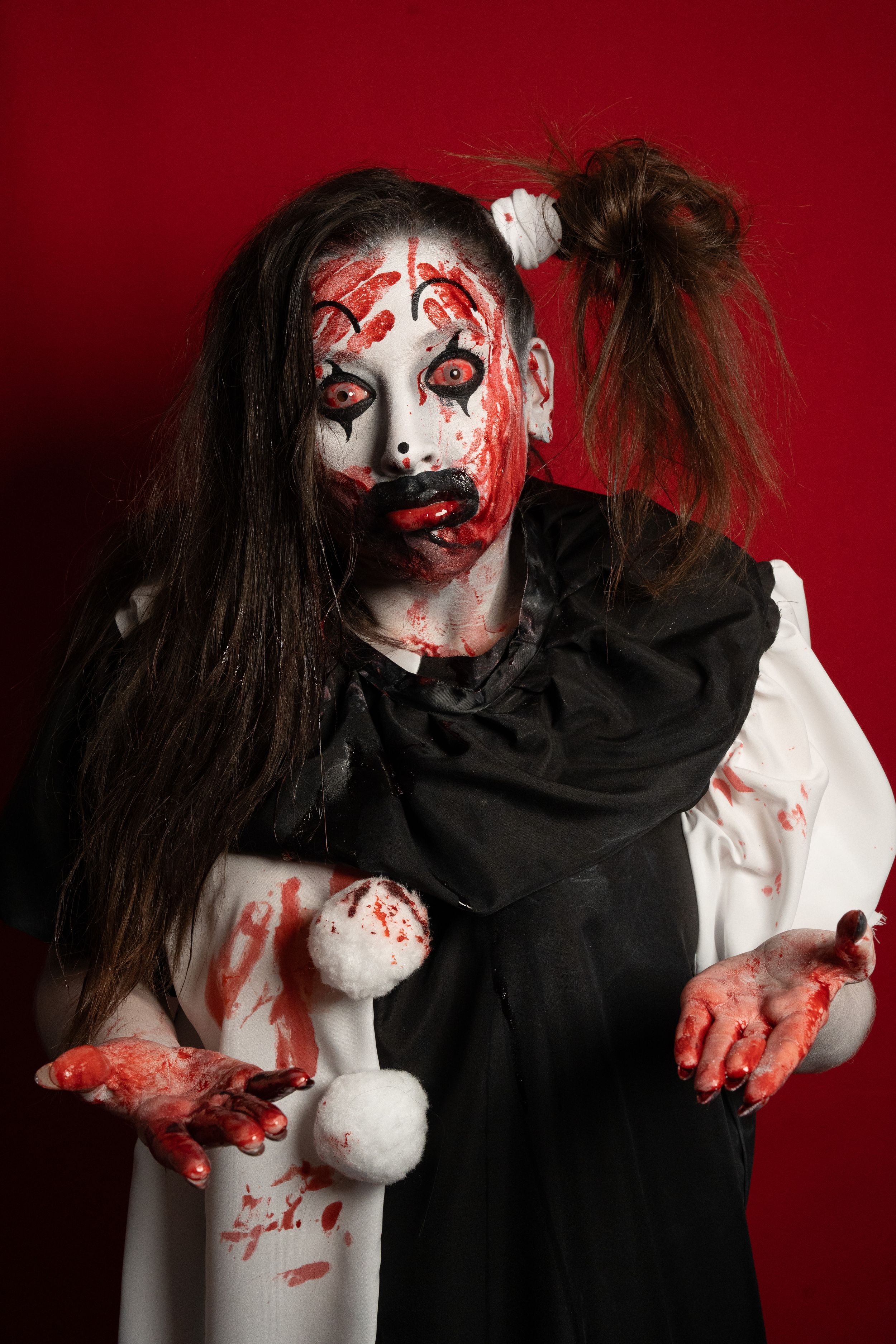 Crazy clown bloody horror funny girl with red eyes special effects makeup.
