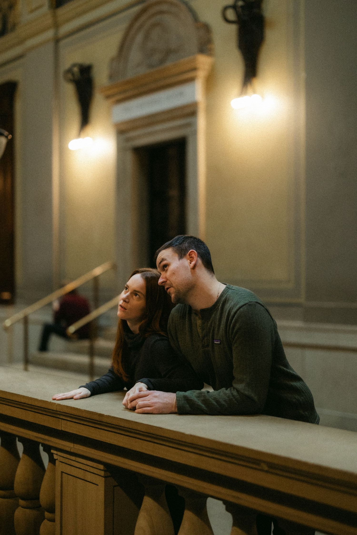 Intimate moment shared in historic building with warm lighting and architectural details.