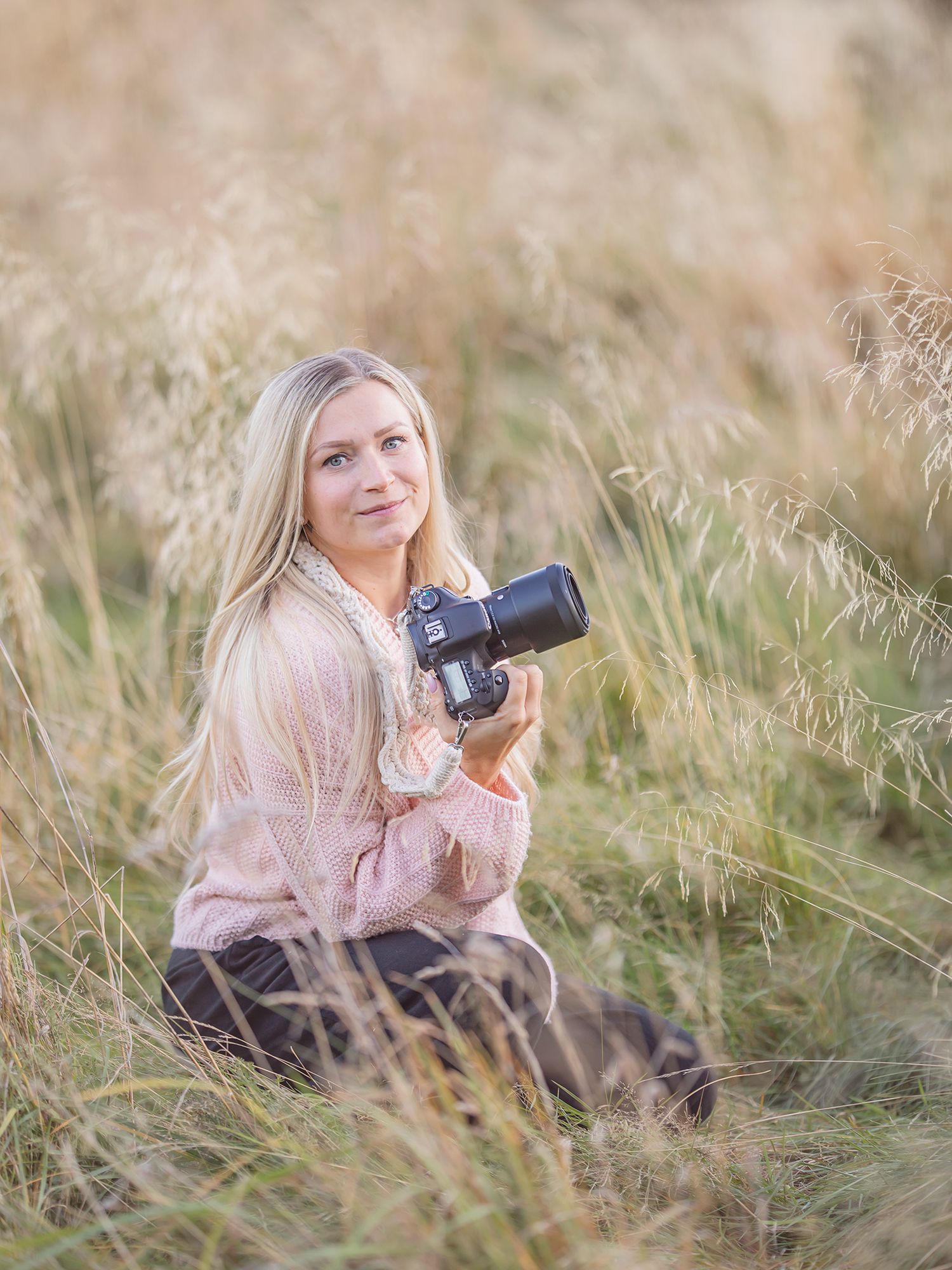 Familjefotograf står på en äng, Familjefotografering i Västerås, Gravidfotografering i Västerås, MemoriebyM