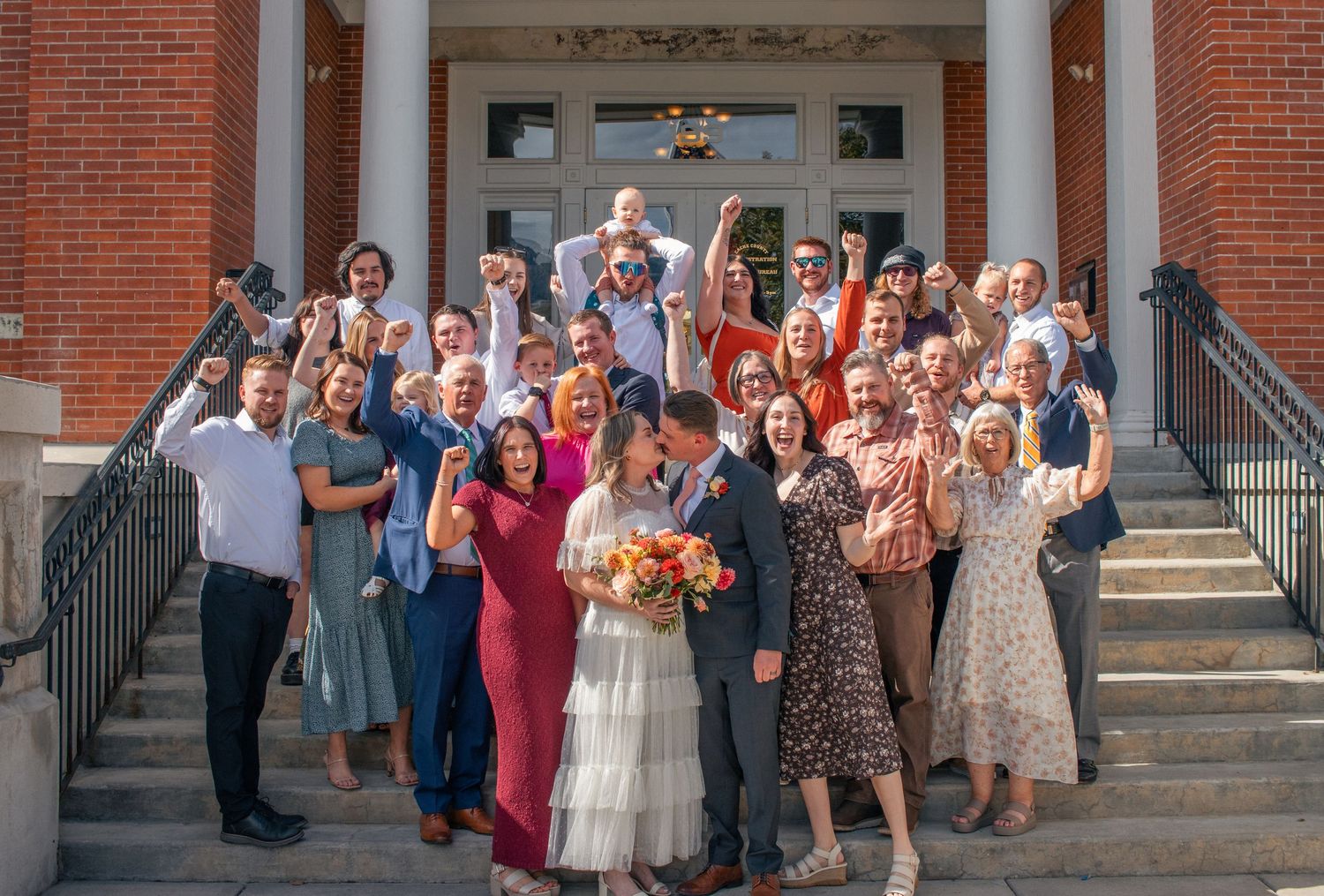 northern utah photography group cheering photo with bride and groom kissing