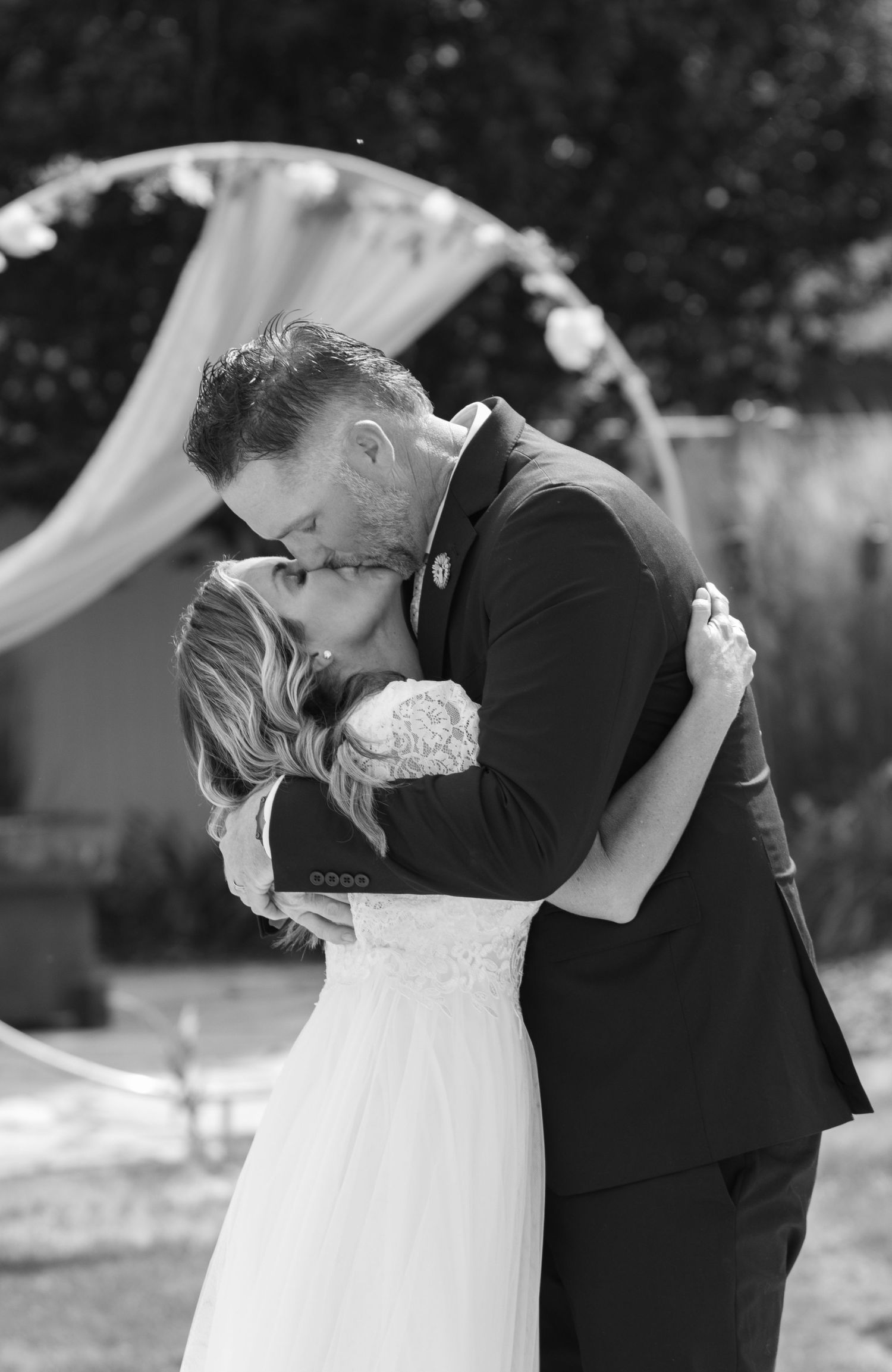Black and white photo of bride and groom sharing a private moment after exchanging vows