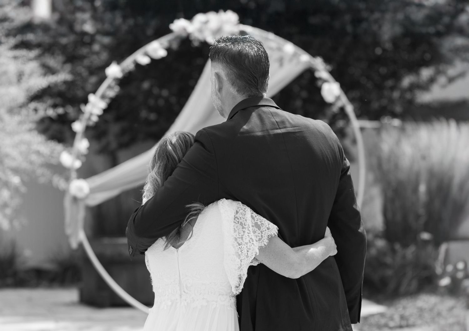Black and white photo of bride and groom sharing a private moment after exchanging vows