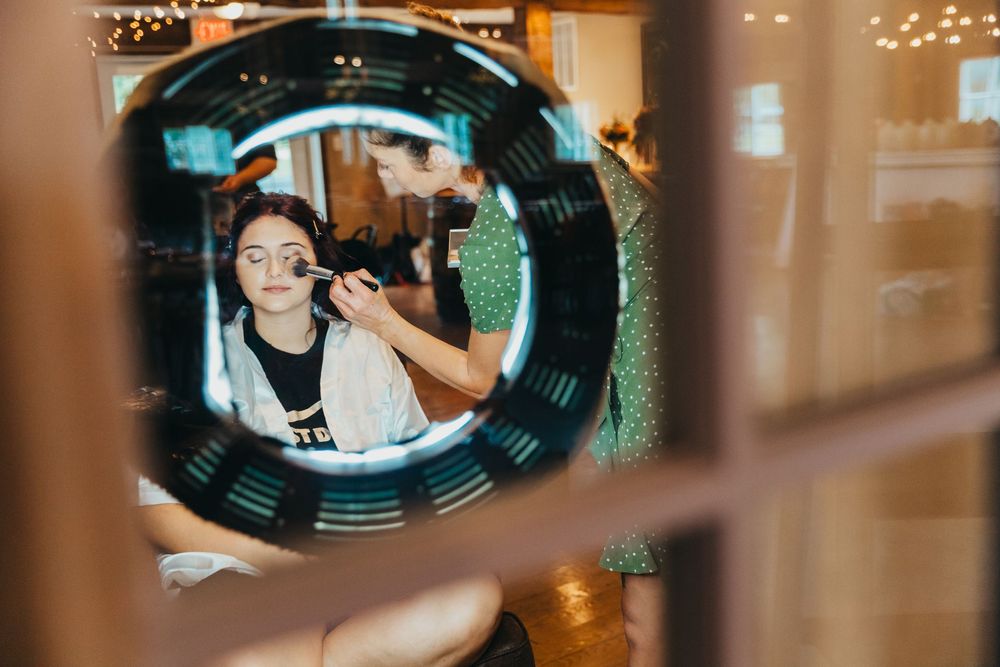 A stylistic view through a round window frame with a reflection and warm lighting in an interior space.