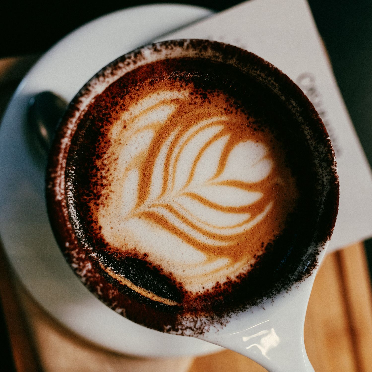 Artistically crafted latte art showing a leaf design in coffee foam.