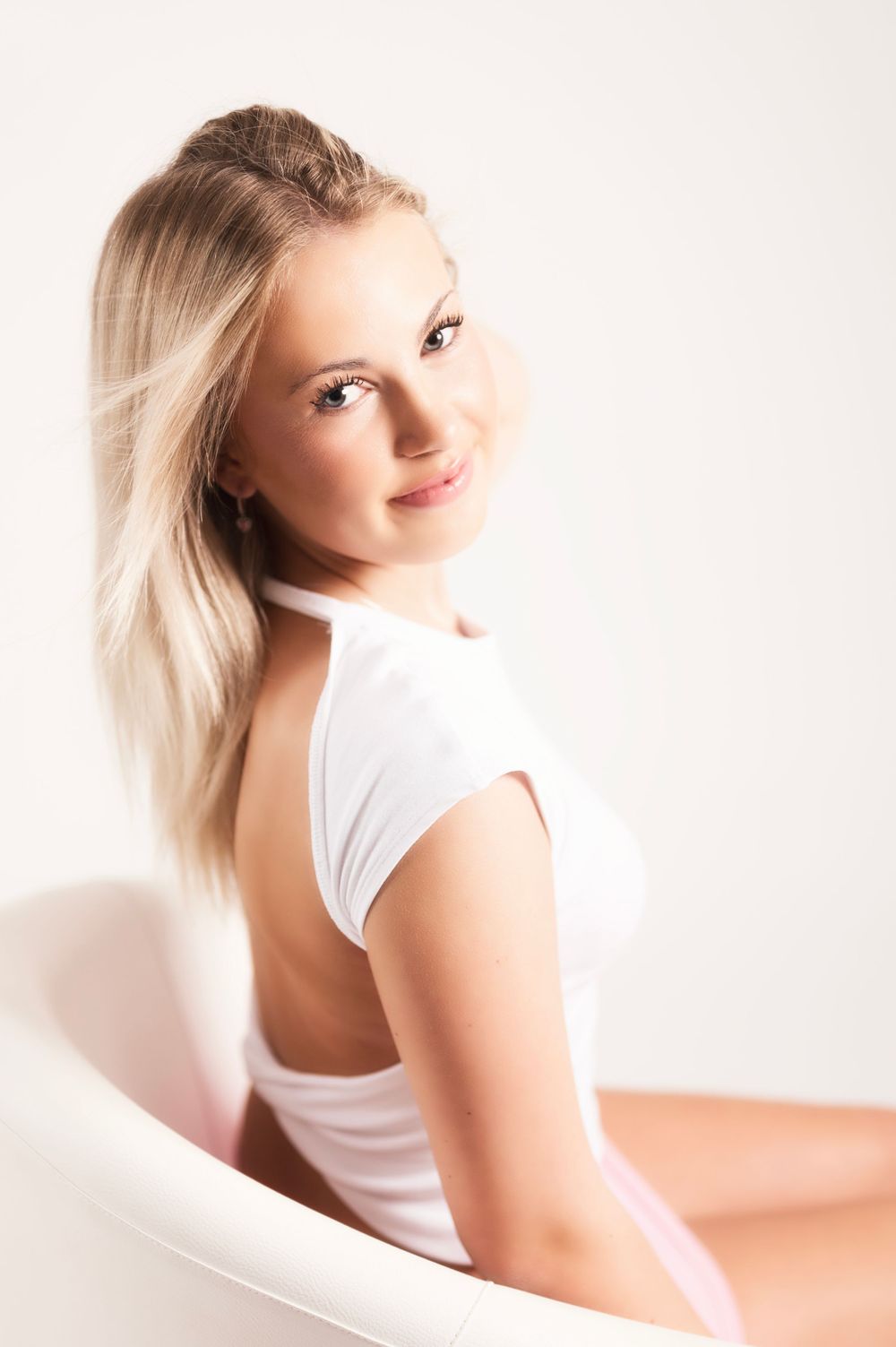 Side profile portrait with natural lighting against clean white studio backdrop.