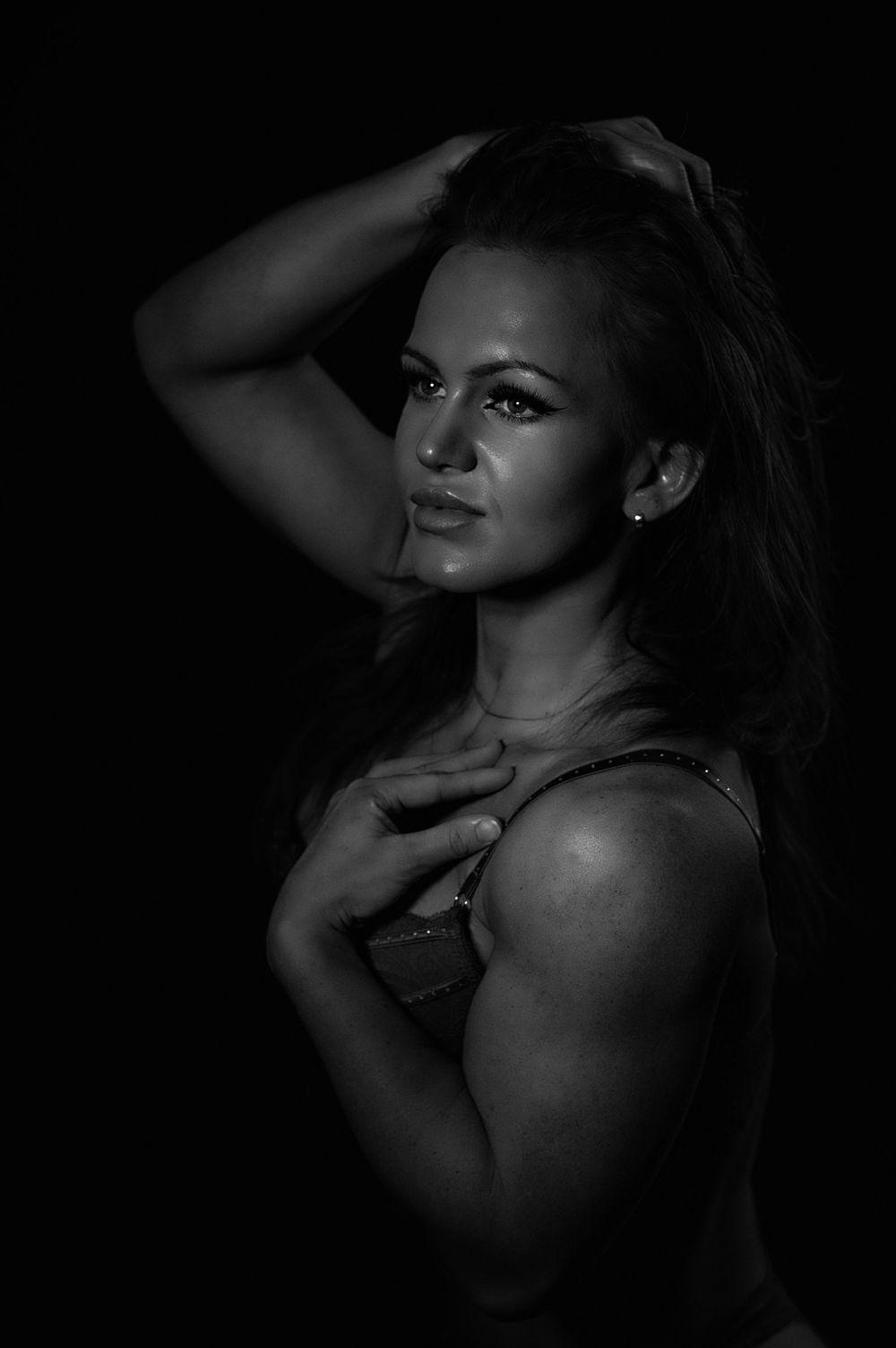 Artistic portrait of a dancer in moody black and white lighting.