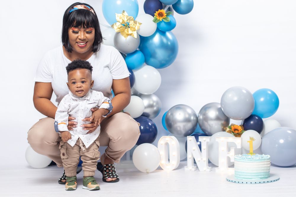 First birthday celebration setup with blue and silver balloons and "ONE" letter decorations.