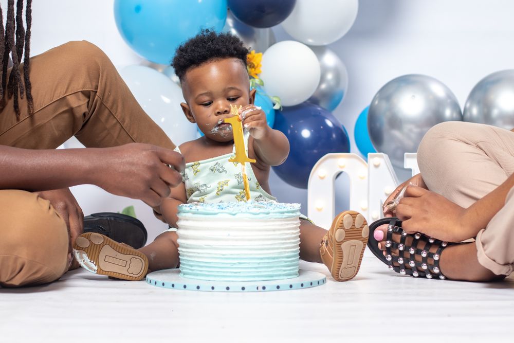 Birthday celebration with blue and white cake and balloon decorations.