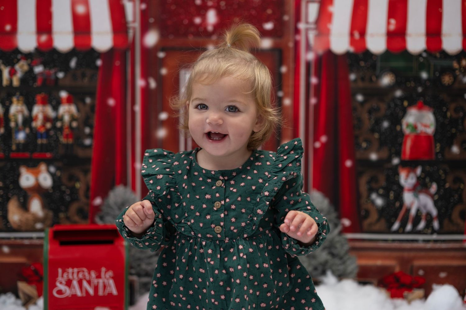 Christmas themed backdrop with little girl smiling at the camera