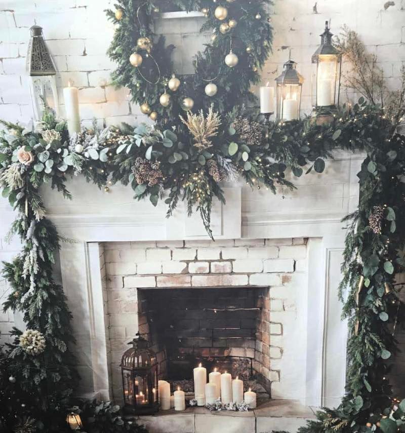 Winter themed photo setup with giant ornaments and twinkling lights in snowy scene.