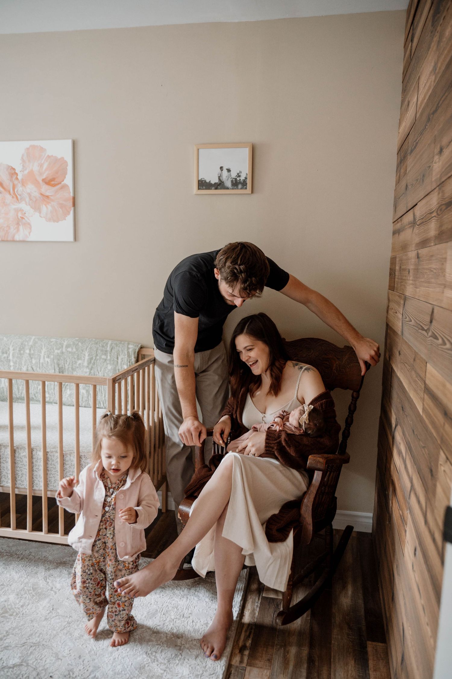 A maternity photoshoot against a white backdrop with a flower basket as prop.