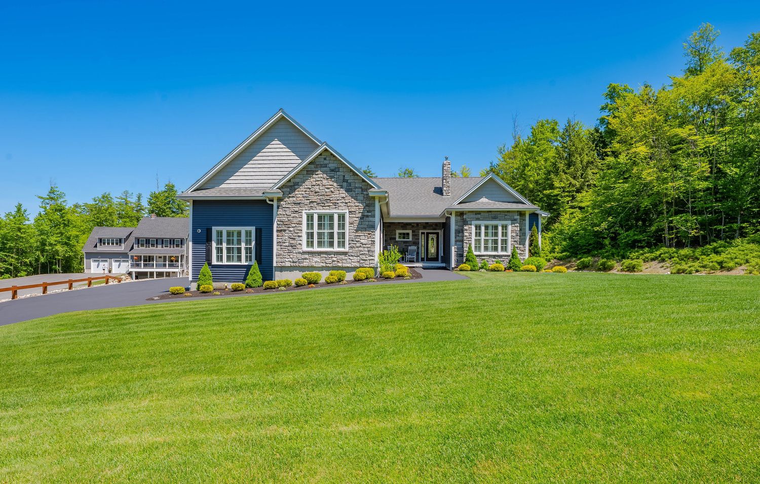 Large modern farmhouse style home with three car garage and gravel driveway.