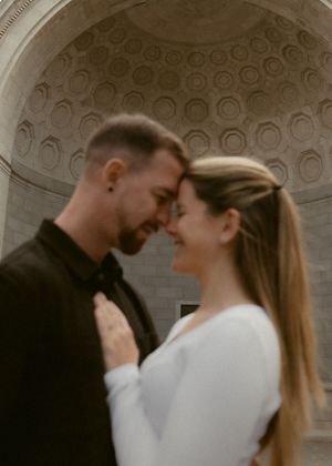 A tender romantic moment shared between a couple under an ornate domed ceiling with circular coffers.