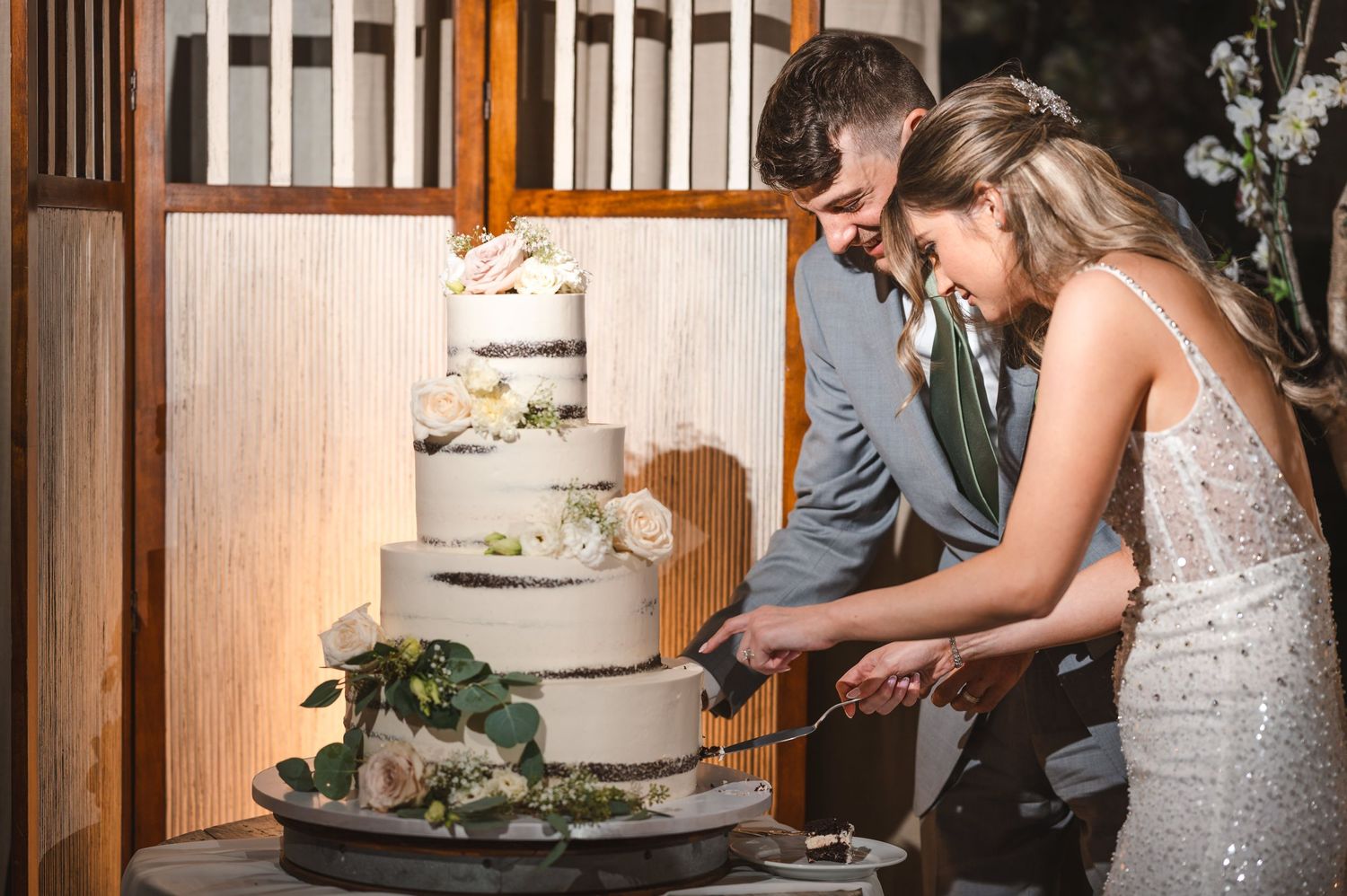 Couple cuts their wedding cake in an elegant barn reception at The Barn at Villa Venezia in Middletown, NY.