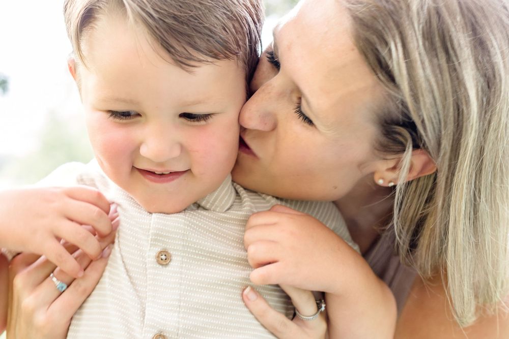 Close-up tender moment between parent and child with soft natural lighting.