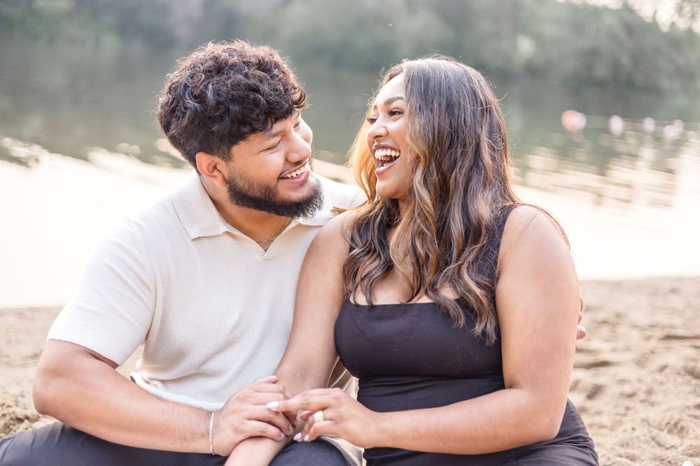 A couple shares a romantic moment while sitting together outdoors in nature.